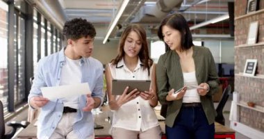 Planlar gözden geçiriliyor, tablet kullanılıyor, çok ırklı ekip iç tasarım projesinde işbirliği yapıyor. işbirliği, takım çalışması, yaratıcılık, mimarlık, beyin fırtınası, teknoloji