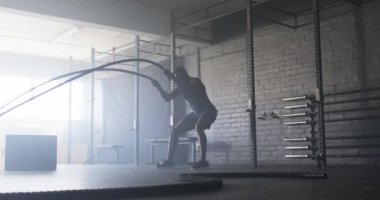 Savaş halatları kullanarak, spor salonunda egzersiz yaparak antrenman yaparak. Fitness, egzersiz, dayanıklılık, kas