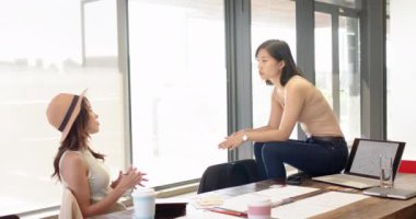 Tasarım fikirlerini tartışmak, modern ofiste kahve ve belgelerle işbirliği yapan çok ırklı kadınlar. İşbirliği, takım çalışması, beyin fırtınası, yaratıcı, iş dünyası, iş arkadaşları