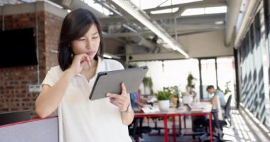 Tablet tutuyor, Asyalı kadın modern ofis çalışma alanında iç tasarım planlıyor, fotokopi odası. teknoloji, yaratıcılık, profesyonellik