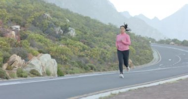 Dağ yolunda koşmak, pembe kazaklı bir kadın dışarıda egzersiz yapmak, fotokopi çekmek. Spor, koşu, egzersiz, aktif, atletik, sağlık