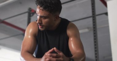 Terleyen ve dinlenen, spor salonundaki adam antrenmana ara veriyor. Fitness, egzersiz, antrenman, kaslı