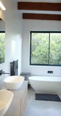 Dikey video: Serbest küvetli modern banyo ve yeşil manzaralı geniş pencere. Lüks, minimalist, spa, rahatlama, sükunet, iç mekan.