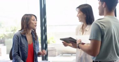 İç tasarım projesini tartışıyorlar, kadın ofiste çok ırklı meslektaşlarıyla tablet tutuyor. işbirliği, toplantı, teknoloji, takım çalışması, planlama, yaratıcılık