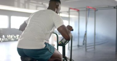 Sabit bisiklette egzersiz, spor salonunda spor yapan bir adam. Egzersiz, egzersiz, kardiyo, bisiklet, dayanıklılık, atlet