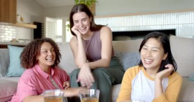 Gülümseyen ve rahatlatan üç kadın arkadaş evde birlikte vakit geçiriyorlar. Arkadaşlık, mutluluk, rahatlama, bağlanma, boş zaman, birliktelik.