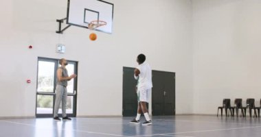 Afrika kökenli Amerikalı erkek basketbolcu, basketbol oynuyor, erkek antrenör spor salonunda gözlem yapıyor. spor, yaşam tarzı ve etkinlik.