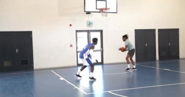 Afrika kökenli Amerikalı erkek basketbolcu koçla hoplayıp spor salonunda talimat veriyor. spor, yaşam tarzı ve etkinlik.