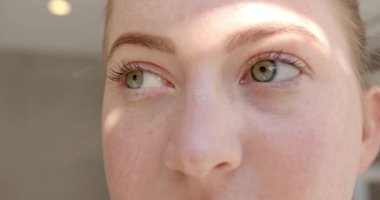 Yeşil gözlerini aydınlatan güneş ışığıyla kadının yüzüne yakın çekim. Güzellik, doğal, yakın çekim, parıltı, değişmemiş,