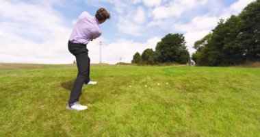 Mavi üniforma giyen, golf oynayan ve golf sahasında golf oynayan erkek bir golfçü. spor, yaşam tarzı, golf ve etkinlik.