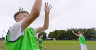 Erkek futbolcular antrenman yapıyor, ısınıyor ve sahada çiftler halinde top atıyorlar. spor, yaşam tarzı, takım çalışması, futbol ve etkinlik.