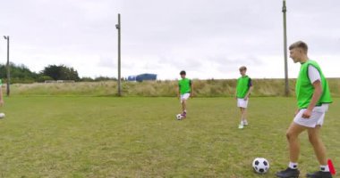 Erkek futbolcular antrenman yapıyor, ısınıyor, koşuyor ve sahada pas veriyor. spor, yaşam tarzı, takım çalışması, futbol ve etkinlik.