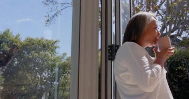 Kahve içmek, sabah güneşinin tadını çıkaran yaşlı bir kadın, fotokopi odası. Rahatlama, içecek, yaşam tarzı, sükunet, sağIık