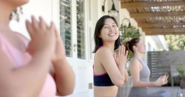 Yoga pozlarında meditasyon yaparken, üç farklı kadın arkadaş evde farkındalık pratiği yapıyor. Meditasyon, sağlık, denge, uyum, sükunet, egzersiz
