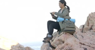 Dağda yürüyüş, akıllı telefon, sırt çantası ve yoga minderiyle fotoğraf çeken bir kadın, fotokopi alanı. Macera, açık hava, doğa, fotoğrafçılık, seyahat, yürüyüş