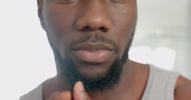 Evde dinlenirken, Afro-Amerikalı bir adam rahat ortamında kendine bakmanın keyfini çıkarıyor. Sağlık, rahatlama, yaşam tarzı, değişmemiş, yavaş çekim
