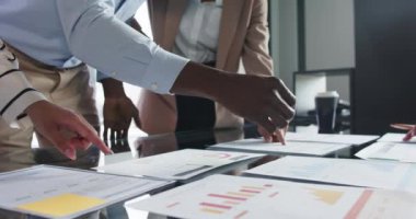 Proje üzerinde işbirliği, çalışma ekibi tablodaki çizelgeleri ve grafikleri analiz ediyor. Takım çalışması, işbirliği, analiz, toplantı, planlama