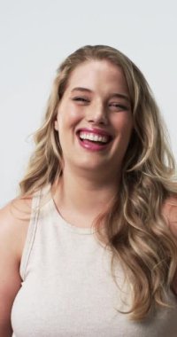 Dikey video: Gülümseme artı cüsseli bir kadının yüzüne dokunması, neşe ve güveni ifade ediyor. Mutluluk, pozitiflik, ifade, duygular, güzellik, portre