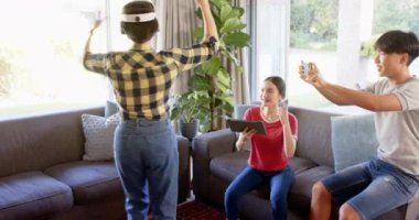 VR oyunu oynamak, aile oturma odasında sanal gerçekliğin tadını çıkarmak. Teknoloji, aile zamanı, eğlence, oyun, eğlence, dalgın