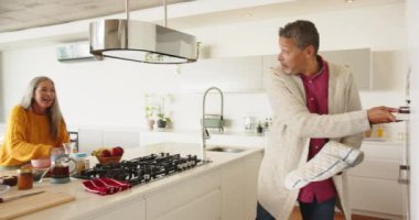 Fırın eldiveni kullanan, modern mutfakta fırın kapısını açan, evde gülümseyen bir adam. Pişirme, pişirme, yerli, mutluluk, ev, yaşam tarzı