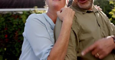 Gülümseyen son sınıf çifti güneşli bahçede birlikte vakit geçiriyorlar. Yaşlılar, yaşlılar, emekliler, açık hava, bahçe işleri, mutluluk.