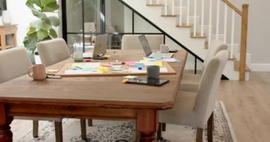 Evde çalışmak, laptoplar ve tabletler masada yapışkan notlar ve kahve kupalarıyla. Uzaktan çalışma, ev ofisi, teknoloji, çalışma alanı, üretkenlik, dijital