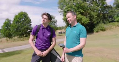 Erkek golfçüler üniforma giyiyor, golf sahasında konuşuyor, golf topu ve golf sopaları tutuyor. spor, yaşam tarzı, golf ve etkinlik.
