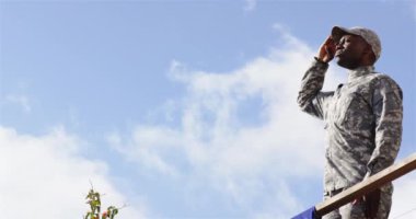 Selamlar, kamuflaj üniformalı asker açık havada mavi gökyüzüne karşı duruyor. Ordu, selam, savunma, vatanseverlik, ordu, hizmet