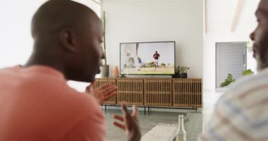 Televizyonda beyzbol maçı izlerken, Afrikalı Amerikalı baba ve oğlu oturma odasında dinleniyorlardı. Spor, eğlence, televizyon, arkadaşlık, eğlence, ev