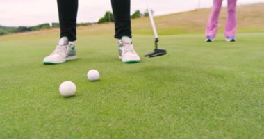 İki kadın ve erkek golf oyuncusu golf sahasında golf oynuyorlar. spor, etkinlik ve golf.