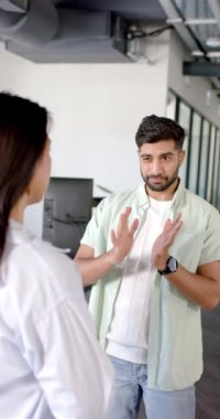 Dikey video: Proje detaylarını tartışmak, iş arkadaşlarının modern ofis ortamında sohbet etmesi. İş, takım çalışması, işbirliği, tartışma, işyeri, toplantı
