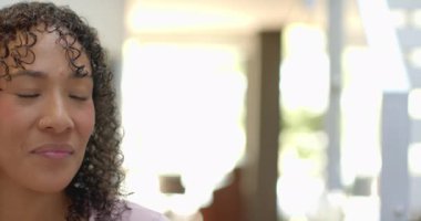 Kıvırcık saçlı, gülümseyen kadın başka tarafa bakıyor, evinde huzurlu bir anın tadını çıkarıyor, mekanı kopyalıyor. Mutluluk, rahatlama, yaşam tarzı, kapalı alan, sükunet, huzur