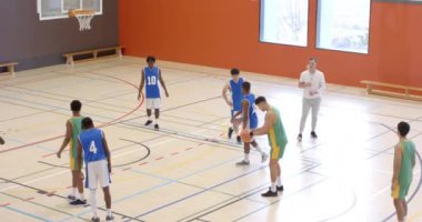 Beden eğitiminde çok ırklı erkek basketbol oyuncuları ve koç gözlemleme maçında basket oynuyorlar. spor, yaşam tarzı ve etkinlik.