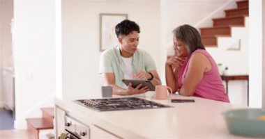 Erkek fizyoterapist, mutfakta yaşlı bir kadınla tablet kullanıyor. Sağlık, fizyoterapi, rehabilitasyon, yaşlılar, danışma, teknoloji