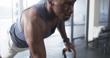 Spor salonunda egzersiz yapmak, yoğun antrenman sırasında ağırlık kaldırmaya odaklanmış bir adam. Fitness, vücut geliştirme, güç, eğitim, egzersiz, kas gücü