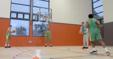 Spor salonunda koçu olan, koşan ve basket atan çok ırklı erkek basketbolcular. spor, yaşam tarzı ve etkinlik.