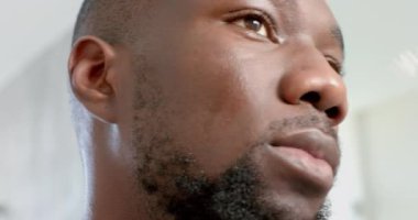 Yüzüne serum sürüyorum, Afro-Amerikalı bir adam spa 'da cilt bakımını seviyor. Bakım, sağlık, yüz bakımı, güzellik, kendine bakım, değişmemiş, yavaş çekim