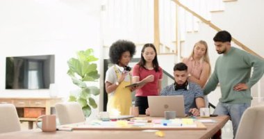 Dizüstü bilgisayar ve tablet kullanan çeşitli genç arkadaş grupları projede işbirliği yapıyor. Takım çalışması, işbirliği, teknoloji, beyin fırtınası, çeşitlilik