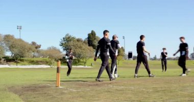 Çok ırklı erkek kriket oyuncularından oluşan iki takım sahada beşlik çakıyor ve birbirlerine sokuluyorlar. Spor, etkinlik, takım çalışması, rekabet ve kriket.