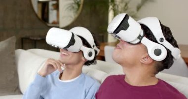 VR kulaklıkları kullanarak, çok ırklı eşcinsel çift evde sanal gerçeklik deneyiminin tadını çıkarıyor. Teknoloji, eğlence, eğlence, sürükleyici, oyun