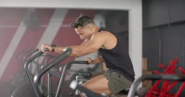 Sabit bisiklette egzersiz yapan, spor salonunda yoğun kardiyo çalışmalarına odaklanan bir adam. Fitness, egzersiz, bisiklet, eğitim, dayanıklılık, sağlık