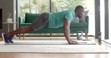 Güçlü ve zinde bir adam yoga minderinin üzerinde kettlebell ile şınav çekiyor. Fitness, egzersiz, güç, egzersiz, eğitim, spor salonu, değişmemiş, yaşam tarzı