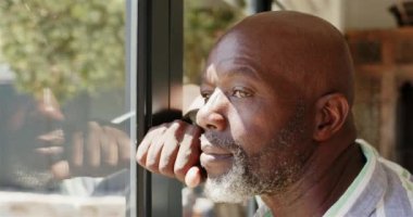 Pencereden dışarı bakan, düşünceli Afro-Amerikan adam hayatı yansıtıyor ve düşünüyor, uzayı kopyalıyor. Düşünmek, düşünmek, düşünmek, yalnızlık, içgözlem, düşünmek.