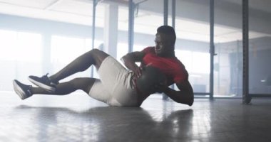 Spor salonunda egzersiz, kırmızı tişörtlü adam yer egzersizi yapıyor. Fitness, egzersiz, eğitim, güç, sağlık, atletizm