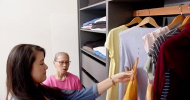 Kıyafet seçmek, Asyalı büyükanne ve torun dolaptan kıyafet almak. moda, aile, perakende, bağ, çok nesilli, yaşam tarzı