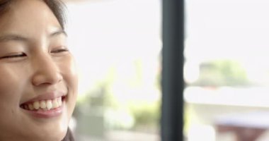 Gülümseyen Asyalı kadın parlak iç mekanın tadını çıkarıyor, mutluluk ve pozitiflik, fotokopi odası, ofiste. Neşeli, neşeli, rahat, kapalı