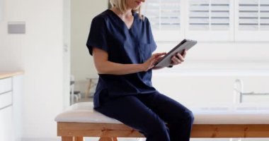 Klinikte tablet kullanan, işe odaklanan önlüklü bir tıp uzmanı. Sağlık, teknoloji, protez, laboratuvar, araştırma, yenilik