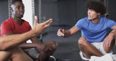 Egzersiz rutini, spor salonunda oturup fitness hedeflerine odaklanan erkekler. egzersiz, eğitim, tartışma, sağlık