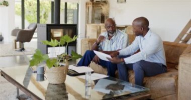 Belgeler, mali danışman ve oturma odasındaki koltukta oturan müvekkil hakkında konuşmak. iş arkadaşları, takım çalışması, işbirliği, iş dünyası, tartışma, toplantı