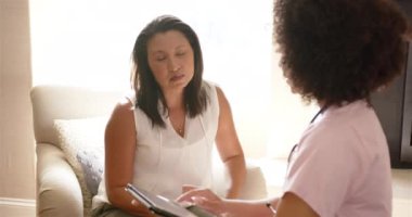 Tıbbi sonuçları tartışıyoruz, hemşire endişeli bir kadına tablet gösteriyor. Sağlık, teknoloji, tartışma, hasta, teşhis